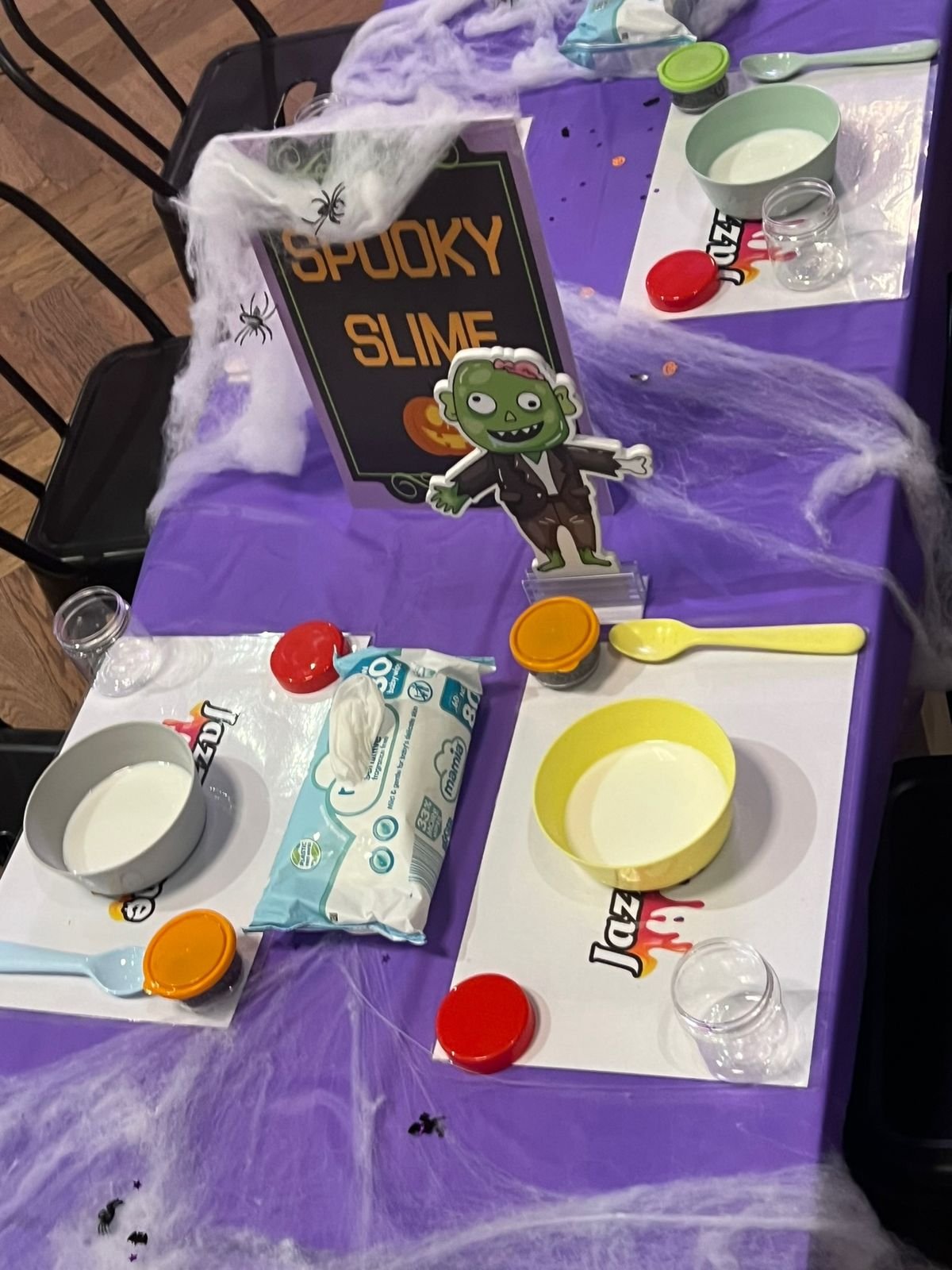 A Halloween-themed 'Spooky Slime' party table setup