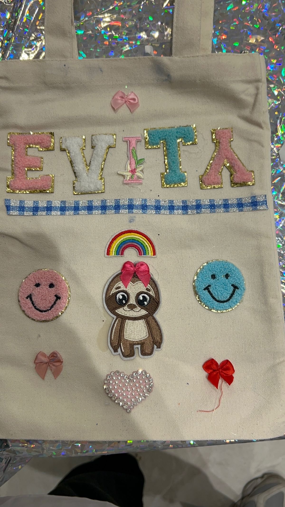 A personalised tote bag decorated with rainbow smiley patches