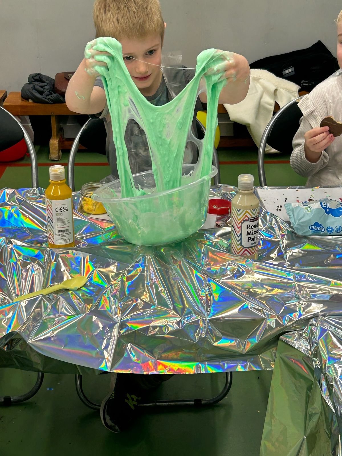 A boy stretching bright green slime overhead